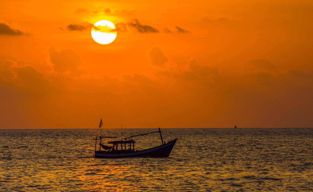 Ảnh bầu trời hoàng hôn trên biển có thuyền 